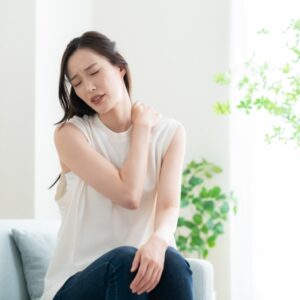 肩こりで辛そうな女性