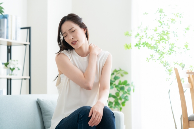 肩こりで辛そうな女性