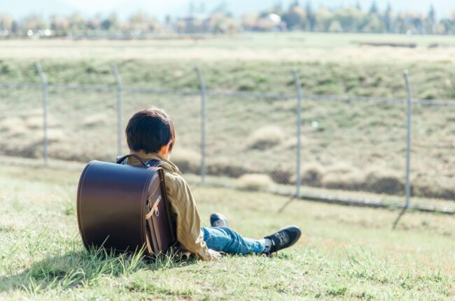 芝生でうつむく少年